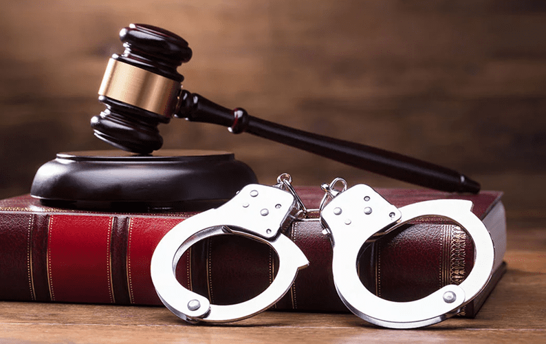 Gavel and handcuffs on law book